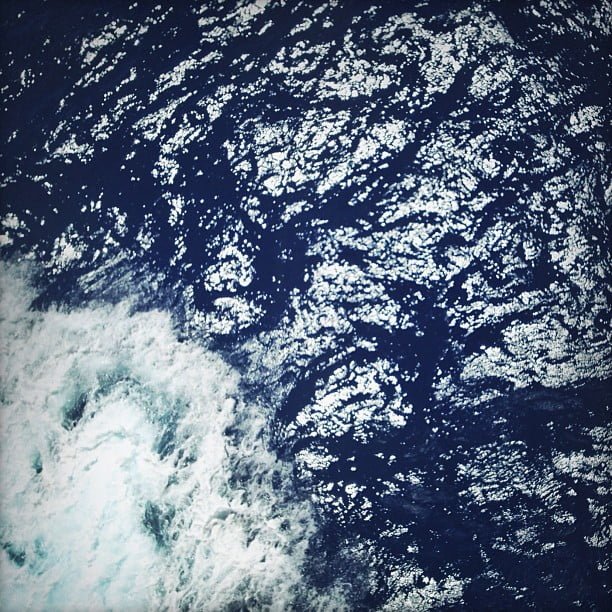 Vista aérea del mar azul oscuro con espuma blanca de olas